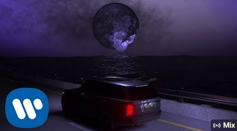 foto coche conduciendo en una carretera sobre el mar con una luna llena gigante